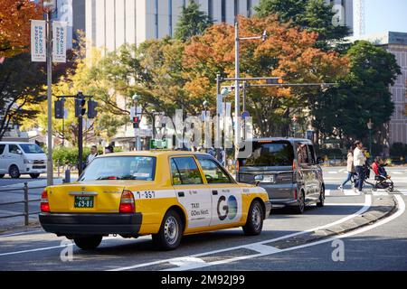 Yellow taxi waiting on a crossroad in the streets of Yokohama Stock Photo