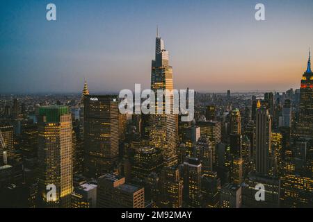 Aerial view of contemporary skyscrapers near tall One Vanderbilt business center with glowing lights in evening New York Stock Photo