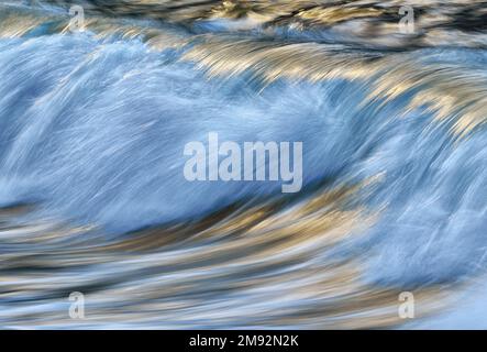 Abstract background of fast stream of water splashing in blue sea with waves on daytime Stock Photo