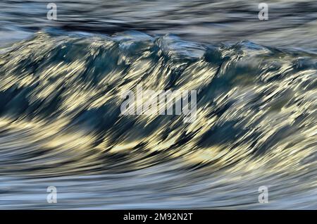 Abstract background of fast stream of water splashing in blue sea with waves on daytime Stock Photo