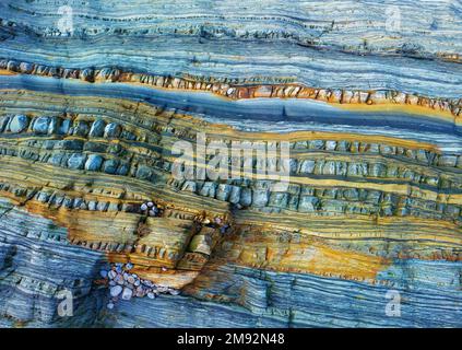 Textured background of uneven surface of brown and blue surface of rough rocky formation in Asturias Stock Photo