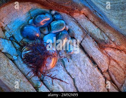 Closeup top view of small round shaped pebbles on rocky surface in Northern Norway Stock Photo