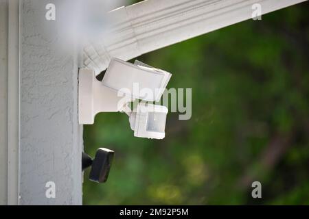 Motion sensor with light detector mounted on exterior wall of private house as part of security system Stock Photo