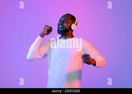 Cheerful black man listening to music and dancing Stock Photo