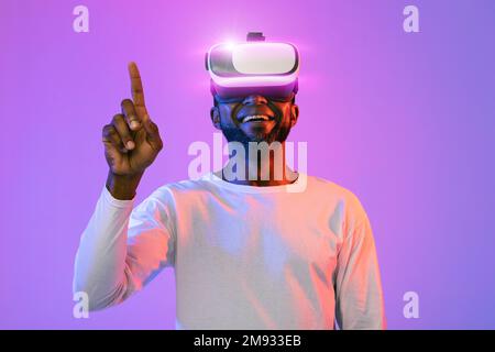 Joyful african american man touching something invisible, trying augmented reality Stock Photo