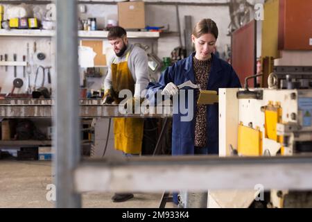 Female locksmith working in metalworking workshop Stock Photo