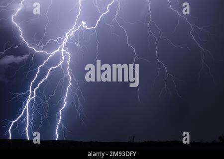Lightning bolts strike in the night sky from a thunderstorm near Phoenix, Arizona Stock Photo