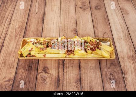 Long yellow porcelain tray with home fries with fried bacon cubes on top Stock Photo