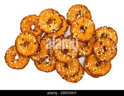 Salted round pretzels with black and white sesame isolated on white. Cracker chips with sea salt isolated on white background. Round shape appetizers. Stock Photo