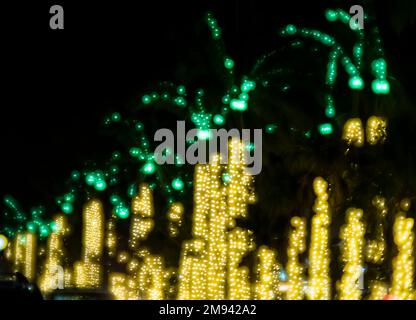 Abstract burred version of gold and green Christmas lights in palm trees in Venice Florida USA Stock Photo