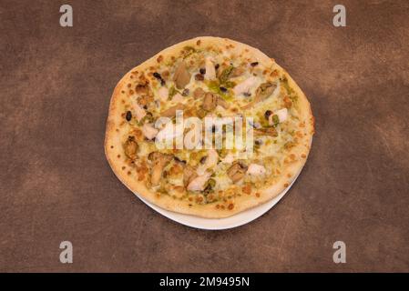 An individual chicken pizza with pesto sauce Stock Photo