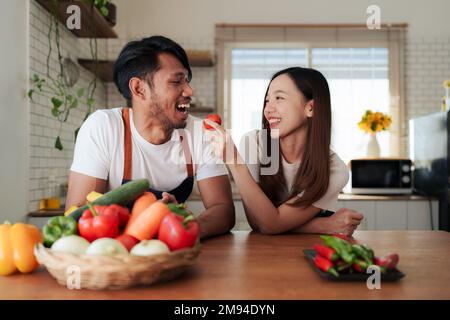 Portrait of young asian couple making salad together at home. cooking food and Lifestyle moment and healthy Stock Photo