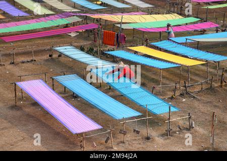 Shantipur, India. 14th Jan, 2023. A view of colourful Indian sarees drying under sun. The saree is a traditional form of dress for women in India. In Santipur & Fulia in the Nadia district of West Bengal, India 90 % of the population are engaged in weaving activities, and have been for generations. Credit: SOPA Images Limited/Alamy Live News Stock Photo