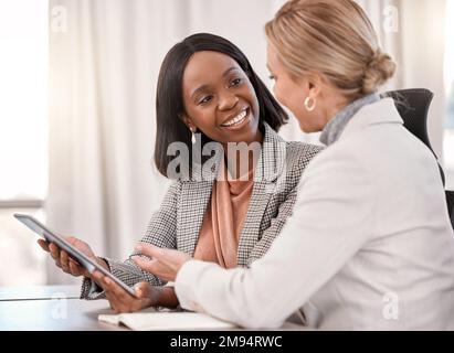 Women in business uplifting one another. two businesswomen planning together while using a digital tablet. Stock Photo