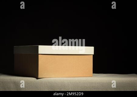 Closed brown cardboard box on black background, copy space Stock Photo