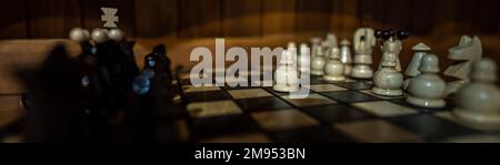 The set of wooden chess pieces element, king, queen rook, bishop, knight, pawn standing on chess board on dark background. Leadership, teamwork Stock Photo