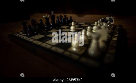 The set of wooden chess pieces element, king, queen rook, bishop, knight, pawn standing on chess board on dark background. Leadership, teamwork Stock Photo