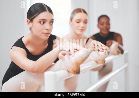 Were all on point. a group of ballet dancers leaning against a barre. Stock Photo