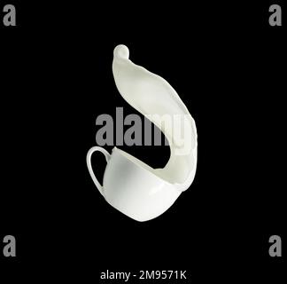 Milk splashing out of cup isolated on black background Stock Photo