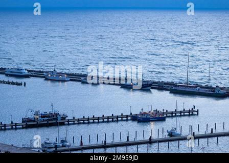 Sassnitz, Germany. 17th Jan, 2023. Excursion ships and fishing boats before sunrise in the city harbor. Stormy and chilly winter weather currently appears in northern Germany. Credit: Jens Büttner/dpa/Alamy Live News Stock Photo