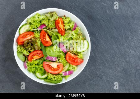 Mixed salad with fresh tomatoes healthy eating food eat from above with copyspace copy space on a slate Stock Photo