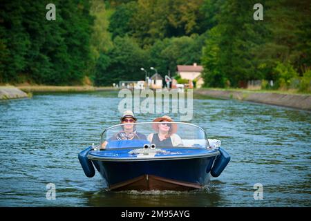 Boat trip on the Canal de la Marne au Rhin (Marne-Rhine Canal), couple on a VINTAGE electric boat between Henridorff and Arzviller, Moselle Stock Photo