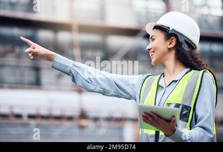 We should check that. a young female architect using a digital tablet at a building site. Stock Photo