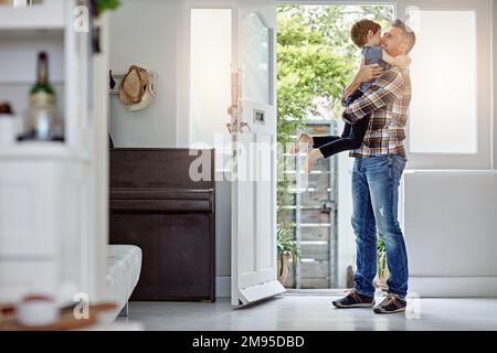 Happy family, love and father hug son, happy and excited to return home, hello and bond. Happy family, greeting and child embrace parent at front door Stock Photo