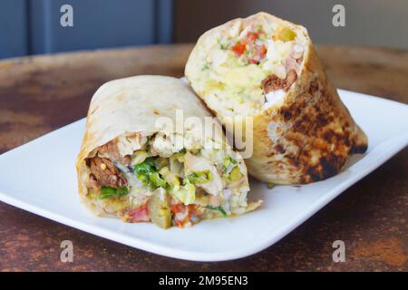 A burrito is a dish of Mexican and Tex-Mex cuisine that was formed in Ciudad Juárez and consists of a flour tortilla wrapped in a sealed cylindrical Stock Photo