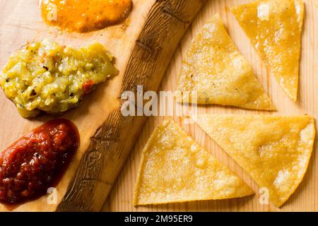 Fried corn tortillas with different hot pepper sauces. Stock Photo