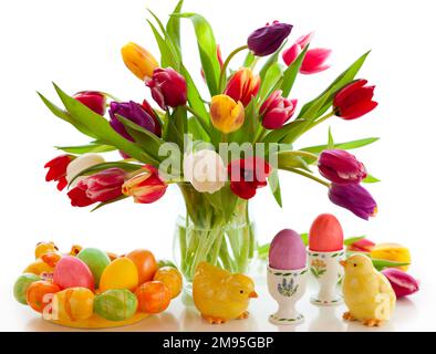 Easter table decorations with bouquet of spring tulips, colorful easter eggs and festive decor. Stock Photo