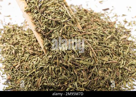 Pile of dried herbs (thyme or oregano) on a rustic wooden spoon, spilling over. Cooking ingredient. Stock Photo