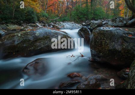A long exposure shot of a river lined with colorful autumn trees in the beautiful Great Smoky Mountains in Tennessee Stock Photo