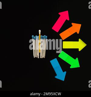 Multi-colored matches on a black background with arrows symbolizing the right to choose. Inclusion. Stock Photo