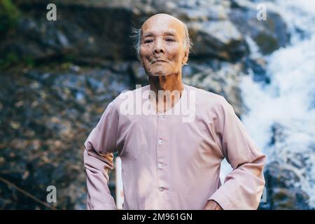 DA LAT, VIETNAM - MARCH 9, 2017: Portrait of an elderly Vietnamese octogenarian in the Park. Authentic Asian grandfather long-liver Stock Photo