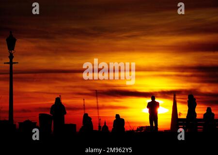 People watch the sun rise from Primrose Hill in west London during a cold and frosty morning. Picture date: Tuesday January 17, 2023. Stock Photo