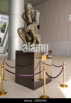 Bronze statue The Thinker by Auguste Rodin on public display in undercroft of OUE Bayfront Building in CBD or Singapore Stock Photo