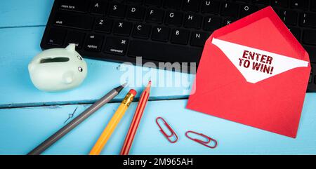 Enter to win. Computer keyboard on a blue office table. Stock Photo