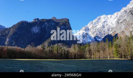 Beautiful blue sky with white and gray rocky mountains and lush green forest, looking from the St. Bartholomä church Stock Photo