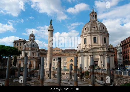 View of Trajan's Column, with St Peter's Basilica on the right, in Rome, Italy.  The column is famous for its spiral bas relief, commemorating the Emperor Trajan's victory in the Dacian Wars. Stock Photo