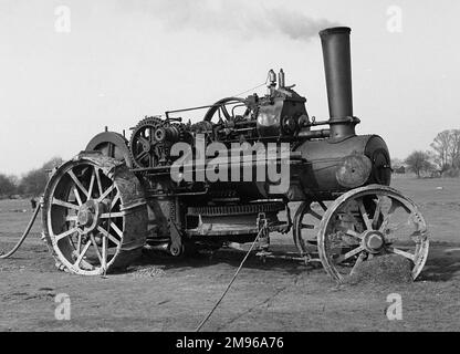 An old steam engine, puffing away in a field, still in use for something or other ... Stock Photo