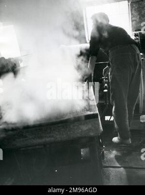 A Blondin winder at work, at Penyrorsedd Slate Quarry, Nantlle Valley, Caernarvonshire (now Gwynedd), North Wales.  The Blondin is a high wire carriage system used to move the slate up or across the pit, as directed by the watcher.  In former days Blondins were steam operated, but the steam in this photograph comes from the water-cooling of the electric motor resistance. Stock Photo