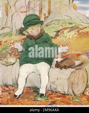 A little girl in a matching green coat and hat sits on a log in a woodland glade feeding a friendly squirrel while a robin nearby looks on. Stock Photo