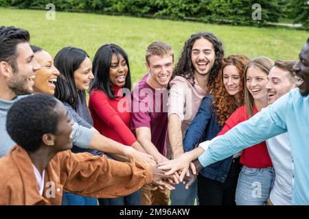 Multiracial people joining hands together, happy friends, peace and love concept, connection of hands of diverse people from the world, joyful image a Stock Photo