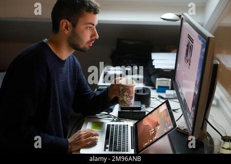 Young man using a computer in Montrouge, France Stock Photo