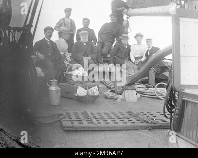 A group of people -- guests and crew -- on the deck of the good ship Effort, during a sea trip, probably off the coast of Pembrokeshire, Dyfed, South Wales. Stock Photo