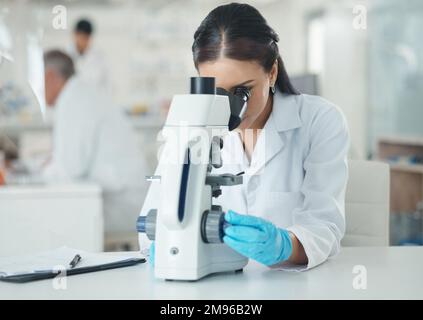 A lot can be deduced from a little. a young scientist using a microscope in a lab. Stock Photo