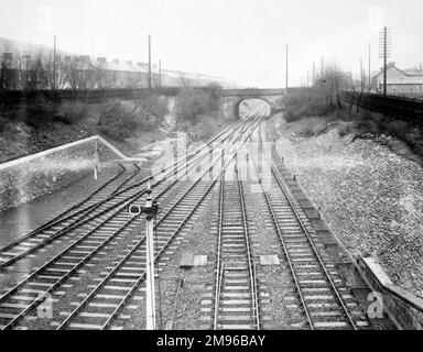 View of the track, with a road bridge in the middle distance, near Skewen Railway Station on the Great Western Railway, Glamorgan, South Wales. Stock Photo