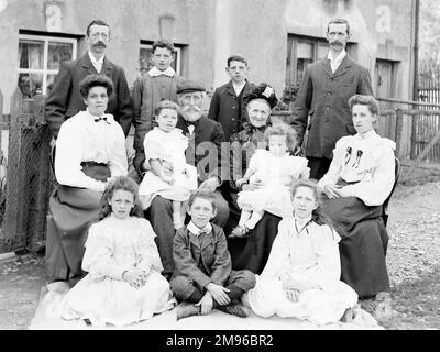 A family group of thirteen, covering three generations, with the grandparents in the middle -- three men, three women, three boys, two girls, and two toddlers. Stock Photo