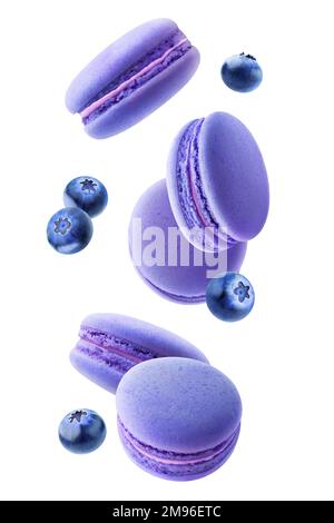Blue macarons and blueberries falling, vertical isolated on white background Stock Photo